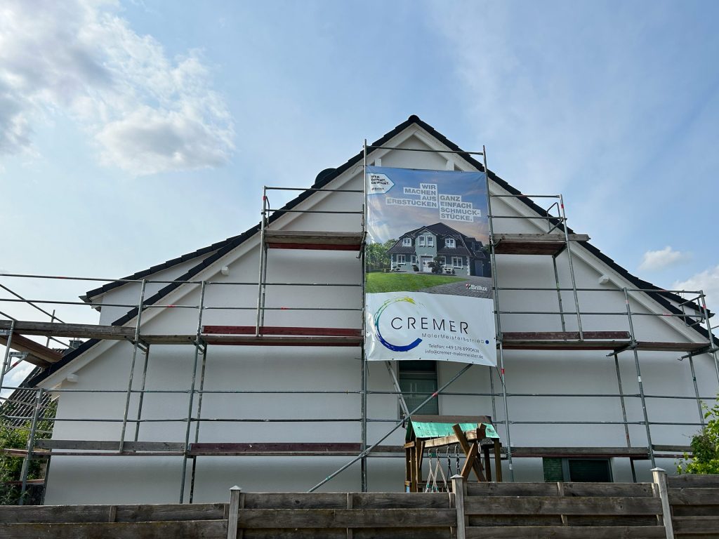 Eingerüstete Hausfassade mit Banner von Cremer MalerMeisterBetrieb